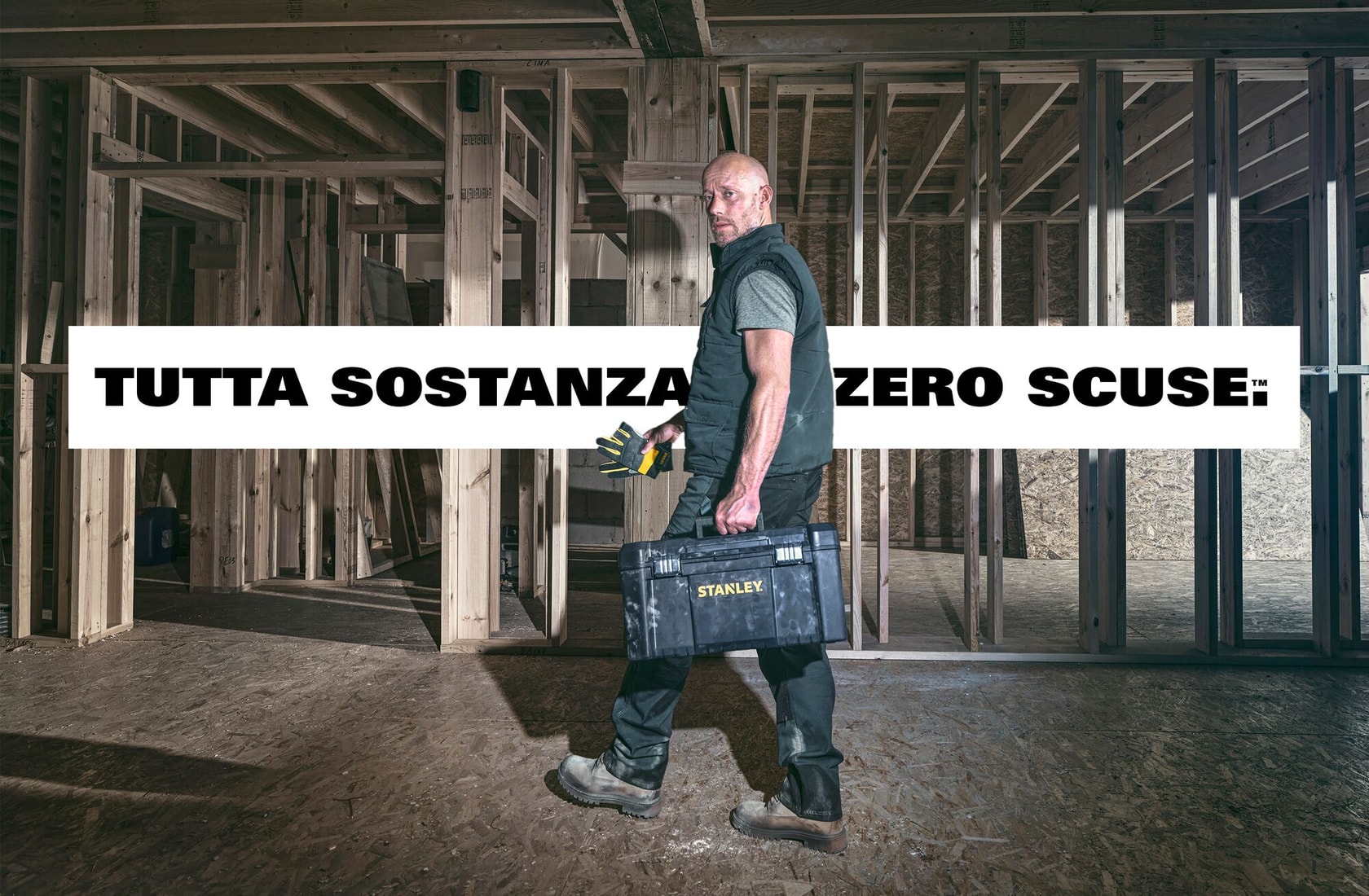 Cassetta attrezzi STANLEY portata da operaio in cantiere, testo in italiano, vista frontale.